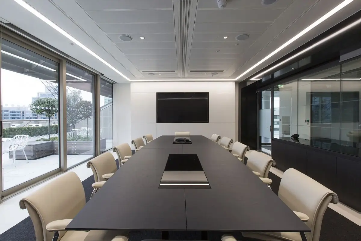 Modern corporate meeting room with a large screen and comfortable chairs