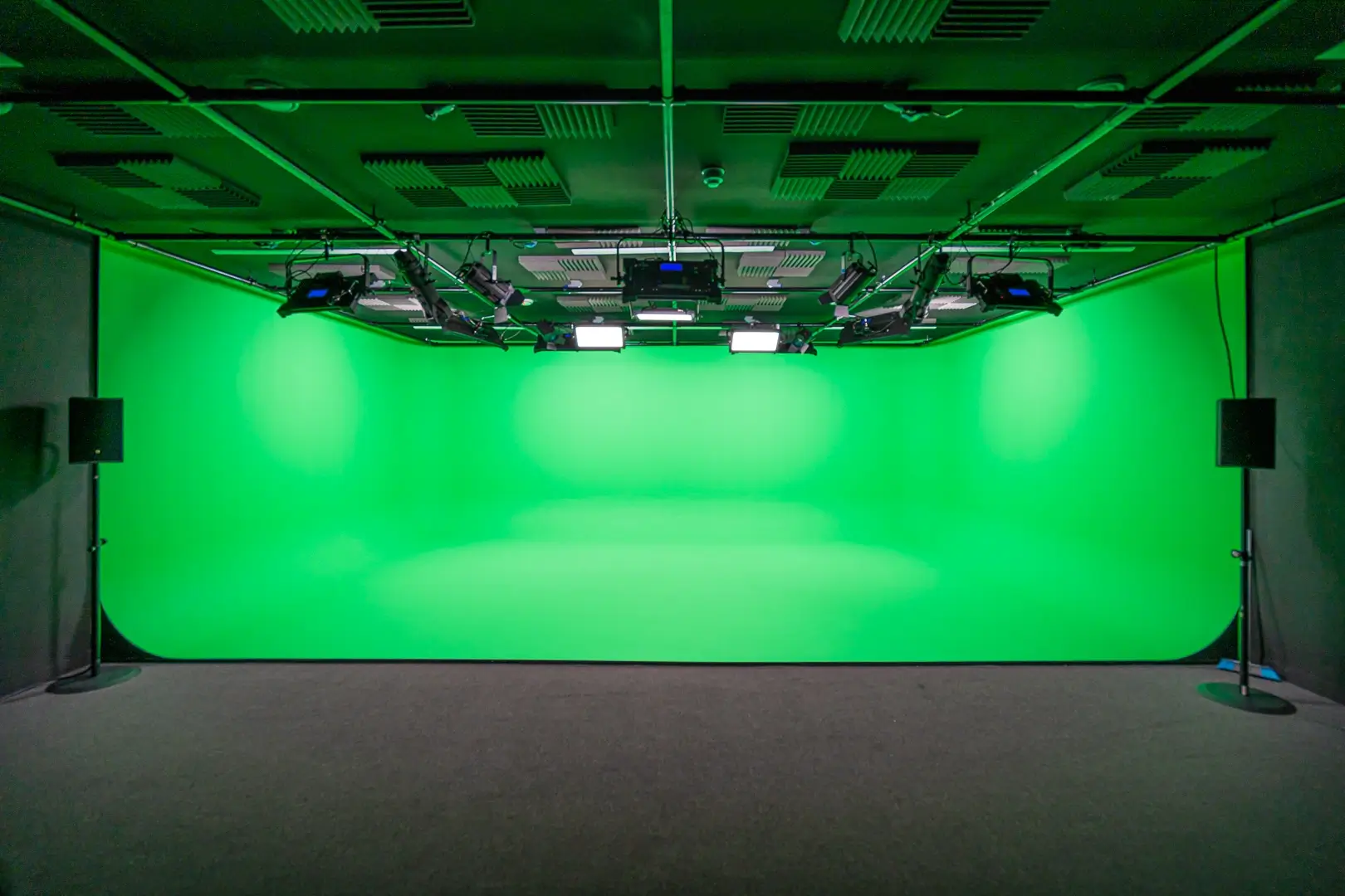A photo studio with a large green screen.