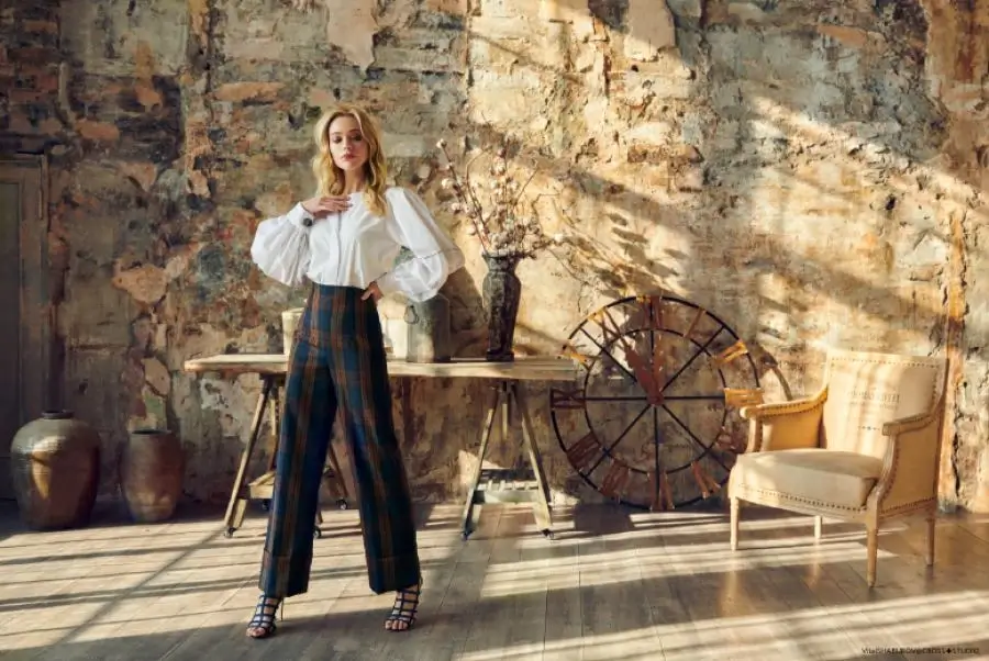 A fashion model posing in a rustic, character-filled loft